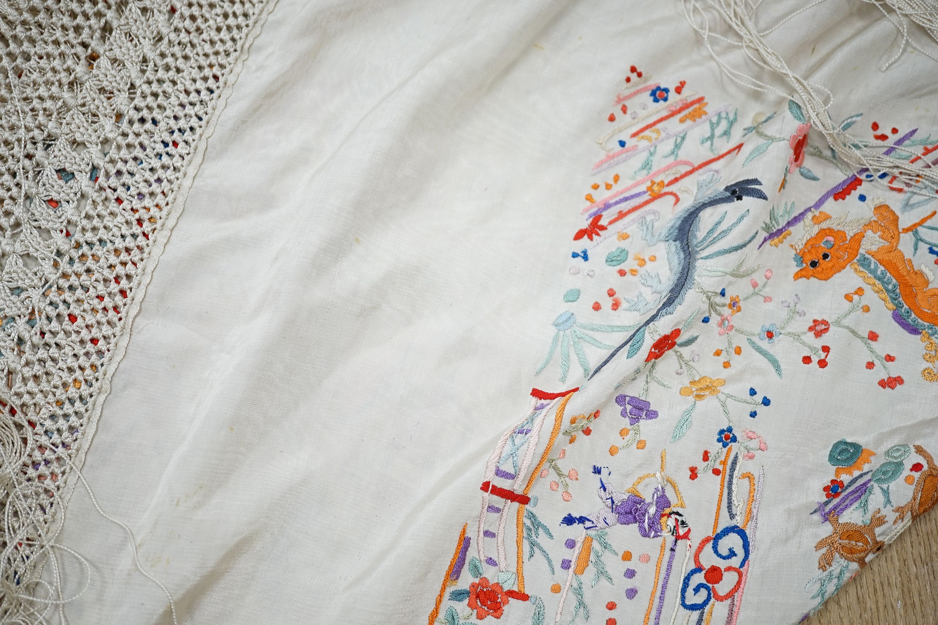 A Chinese cream silk shawl with fine multi coloured all over embroidery depicting figurative scenes and animals